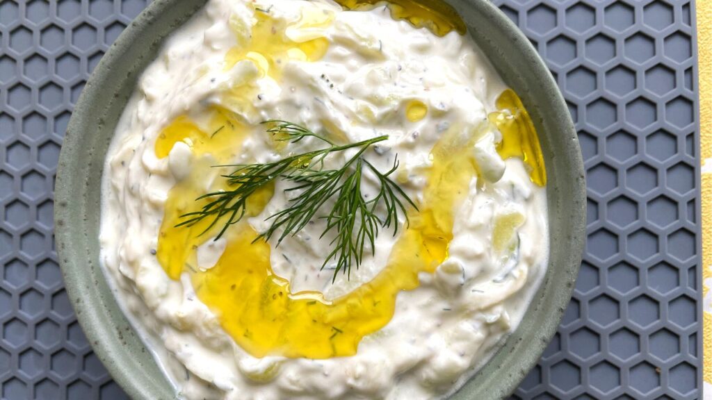 Tzatziki Sauce served in a small bowl with olive oil drizzle and dill on top