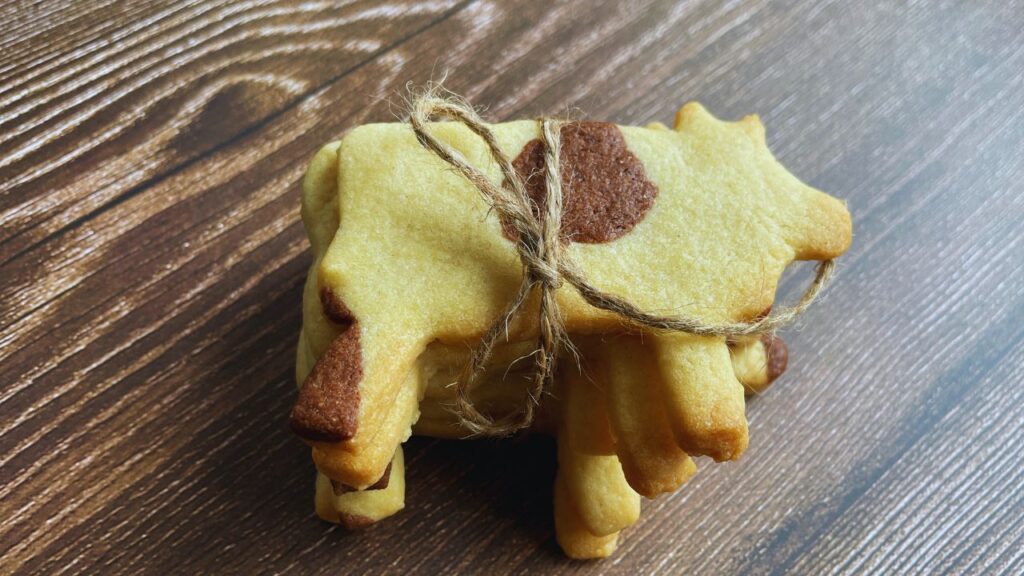 Cow shaped butter cookies ties with thread on  wooden board