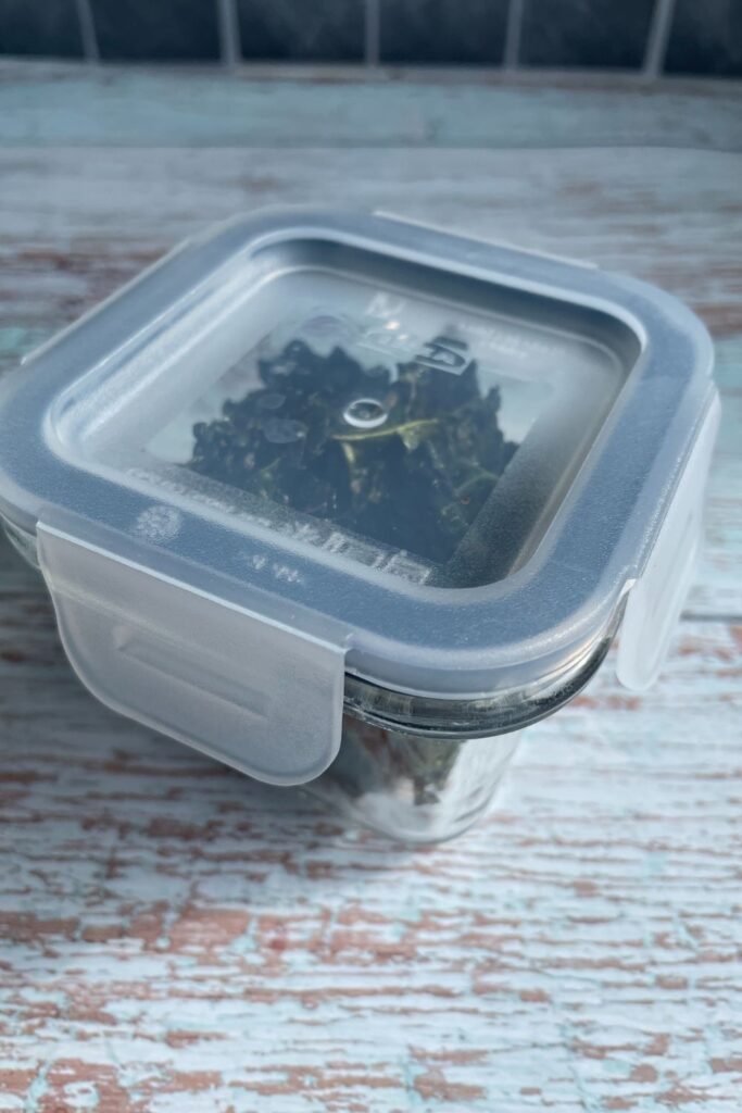 Kale chips stored in a small air tight glass container