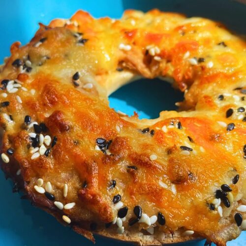 Freshly baked air fryer tuna melt on bagel served in a blue plate