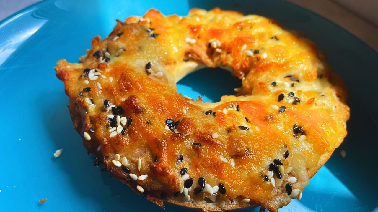 Freshly baked air fryer tuna melt on bagel served in a blue plate
