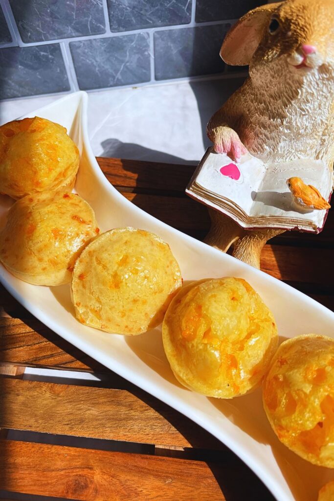 Freshly baked Brazilian cheese breads served in a stylish plate on a wooden board