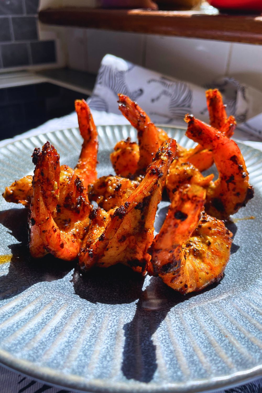 Grilled Tiger Prawns served on a blue-and-white patterned rectangular plate.