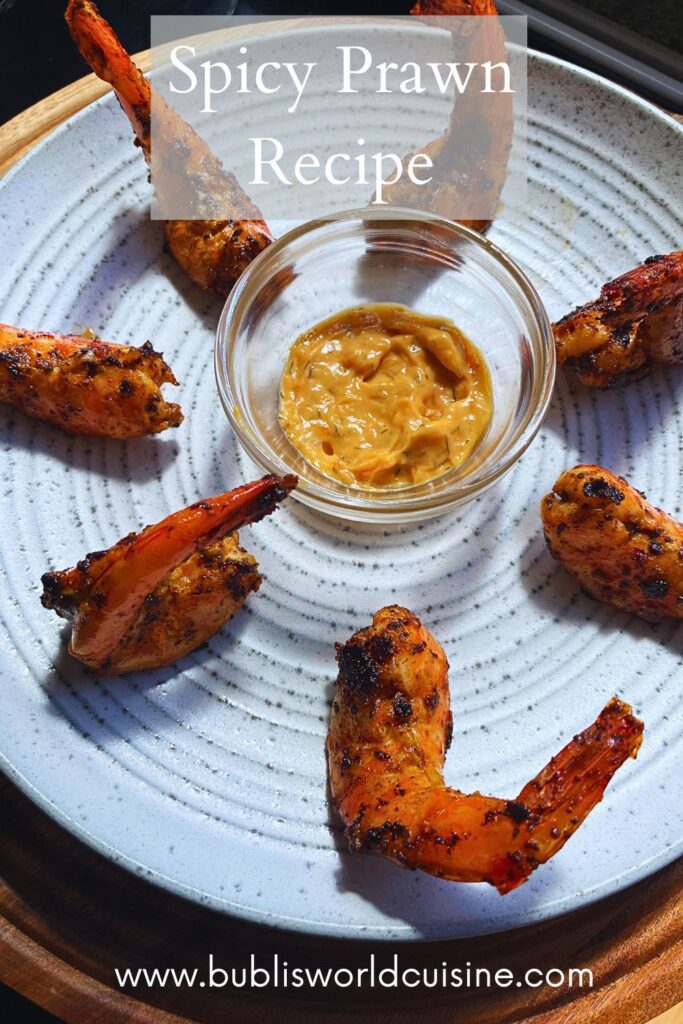 Spicy tiger prawns served in a plate with some dipping sauce.