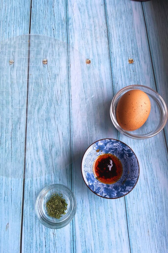 Rice paper omlette ingredients laid on a blue wooden board