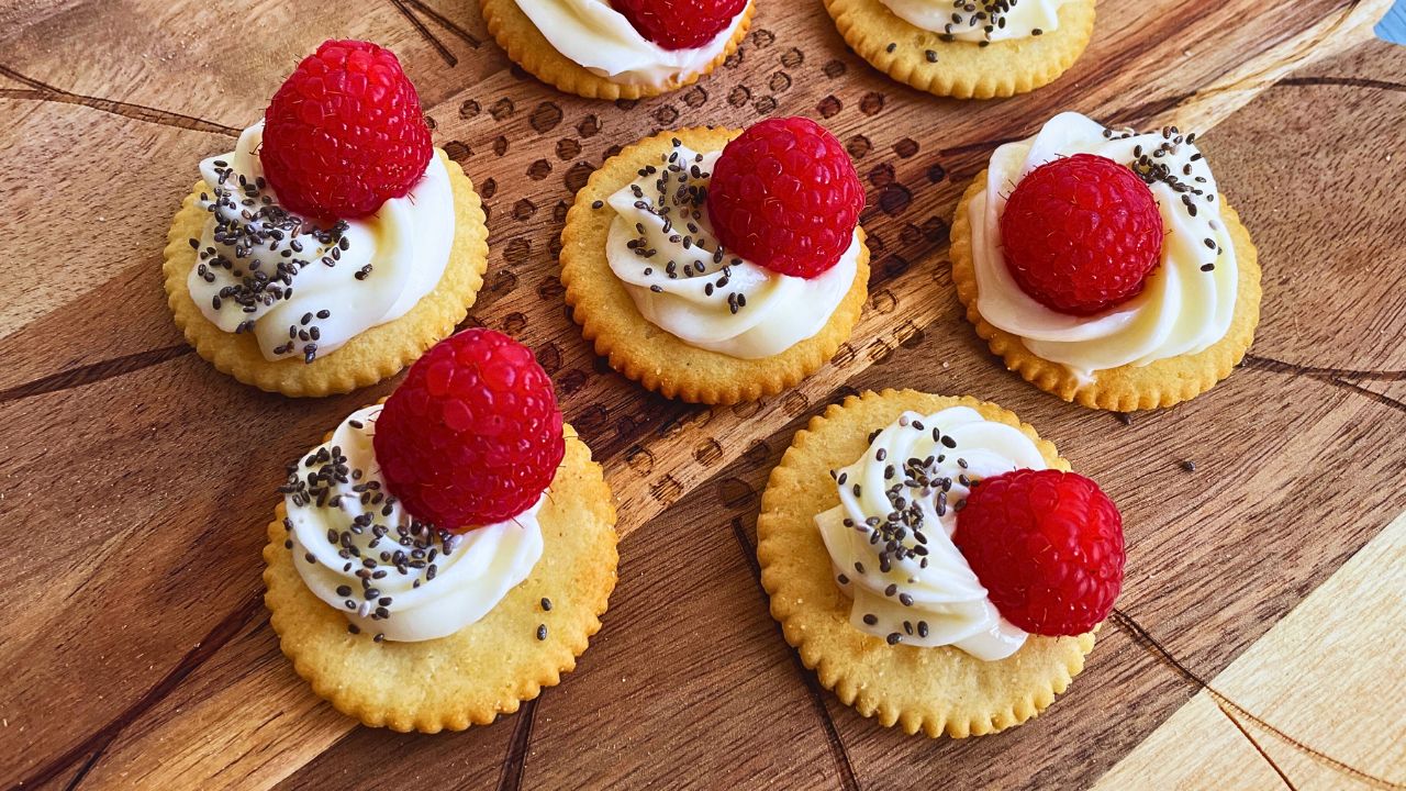 Party Appetisers Raspberry & Cream Cheese Crackers served on a wooden board