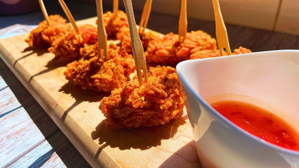 Walkers crispy chicken bites in air fryer served on a wooden board with some sauce