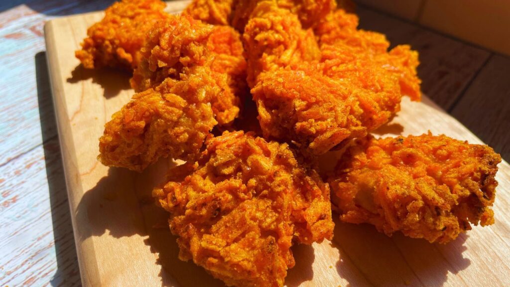 freshly made golden crispy chicken bites served on a wooden board