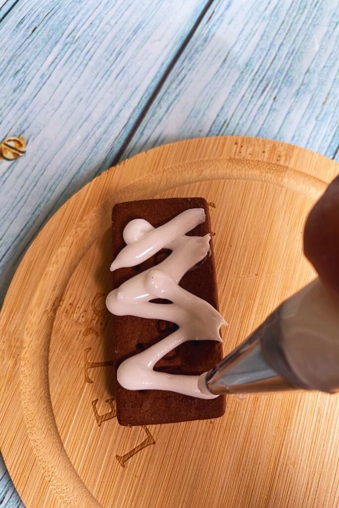 Sugar paste piping on bourbon biscuit for halloween mummy biscuit