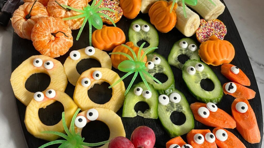 Halloween Fruit Platter with oranges, apples, carrots, grapes, cucumbers